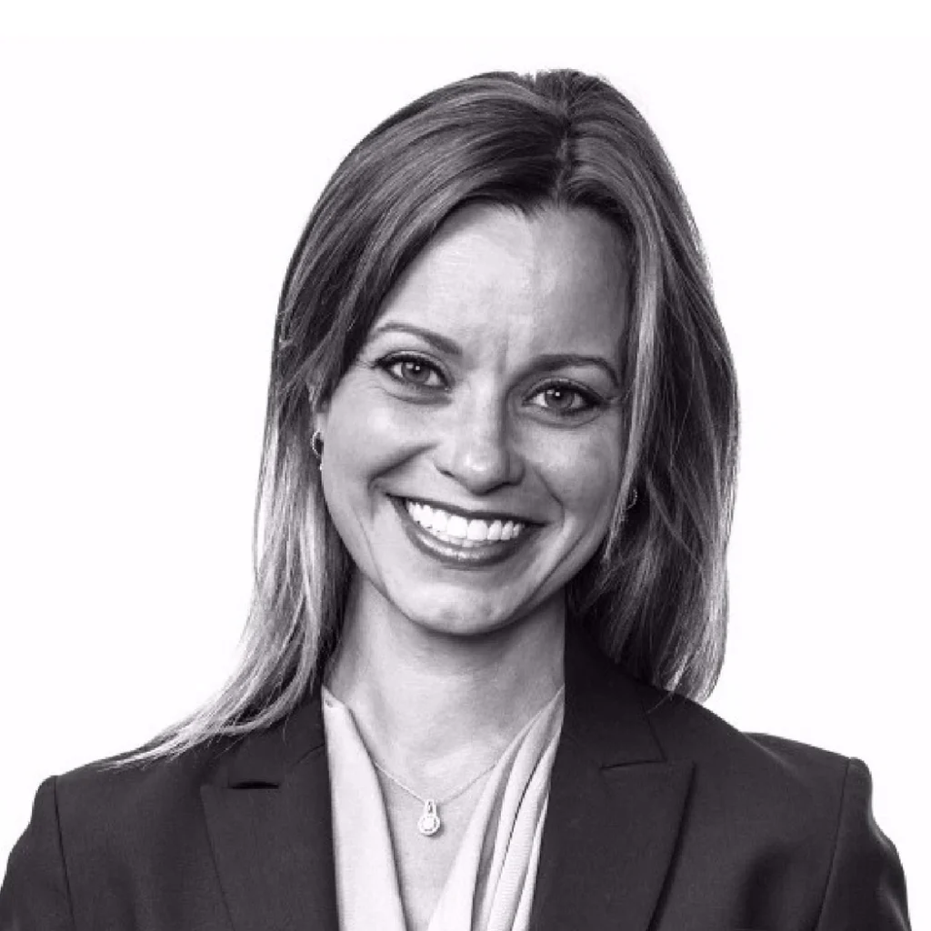 Professional headshot of COO Kate Wilhelm smiling at the camera, wearing a blazer.