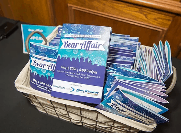 A stack of blue and purple cards in a basket for a Philadelphia Children's Alliance event.