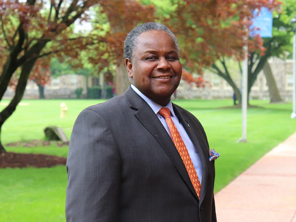 Leader at Cheyney University smiling in a suit on campus