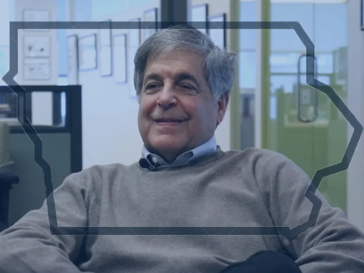 Larry Ceisler smiling during an interview, wearing a buttondown and sweater