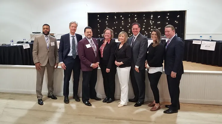 A group of eight professionals standing together at an event