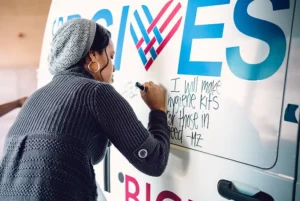 A woman writing on a whiteboard for Giving Tuesday