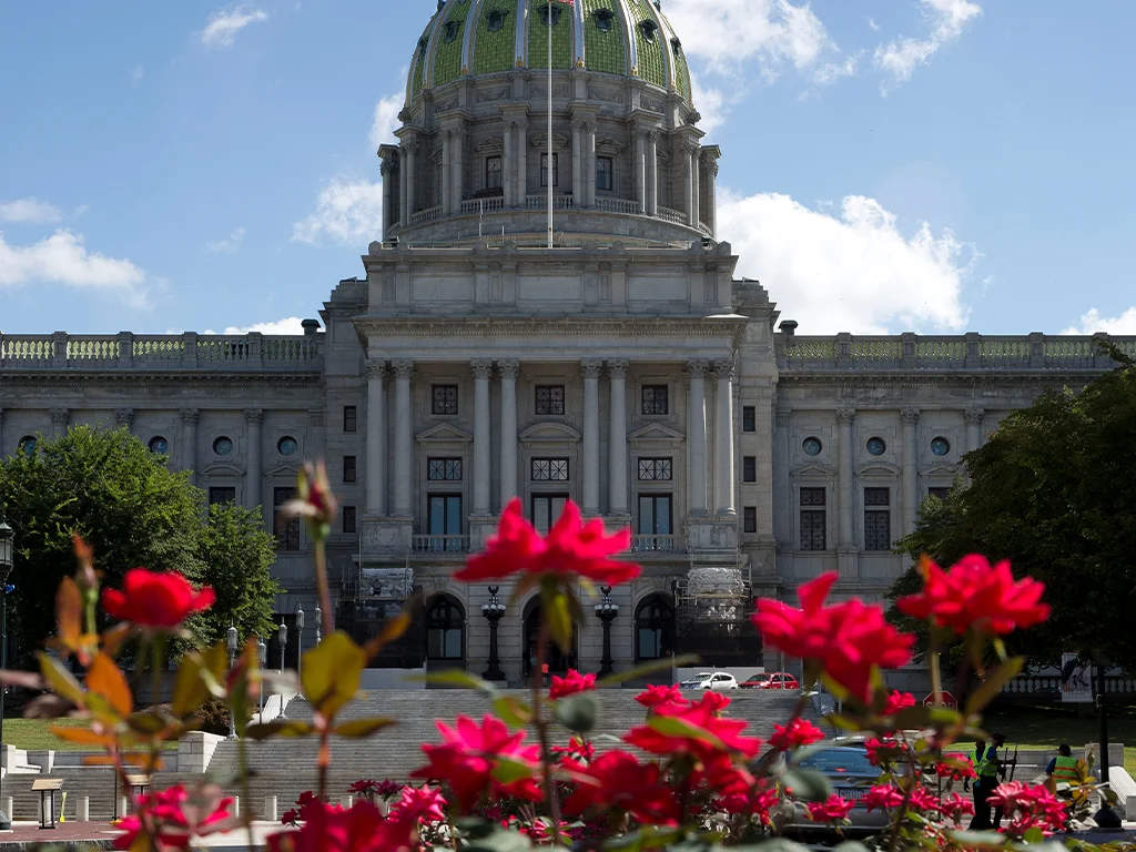 Harrisburg Capitol building with red flowers blooming in the foreground