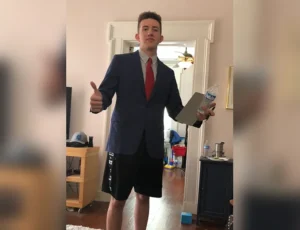 Joey Georgy wears a suit and tie with athletic shorts to represent his attire for remote work