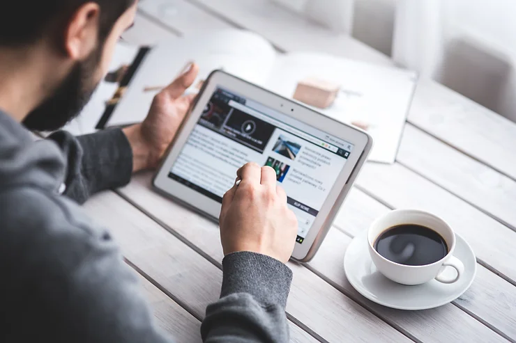 Man on a tablet sitting at a cafe to read the news