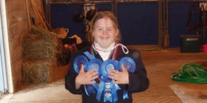 A girl stands with medals at the special olympics