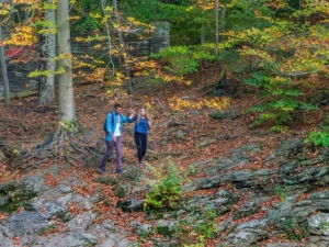 Two people walking hand-in-hand in a wooded area, courtesy of Visit Philadelphia